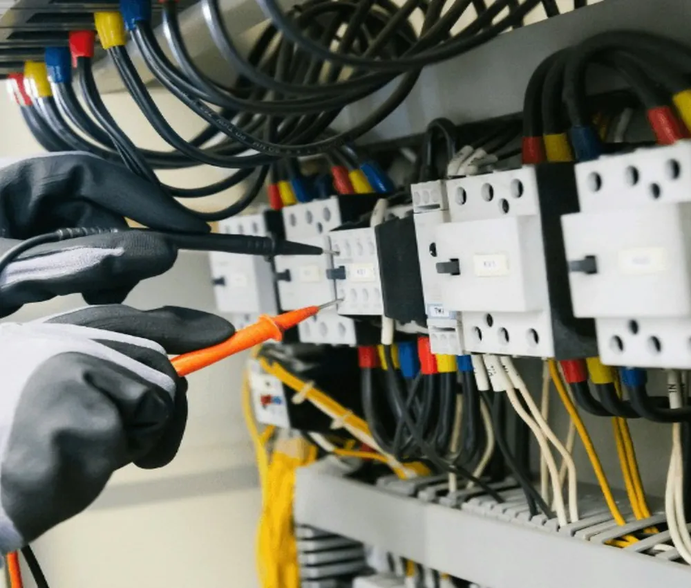 Ingeniero verificando un tablero eléctrico con multímetro