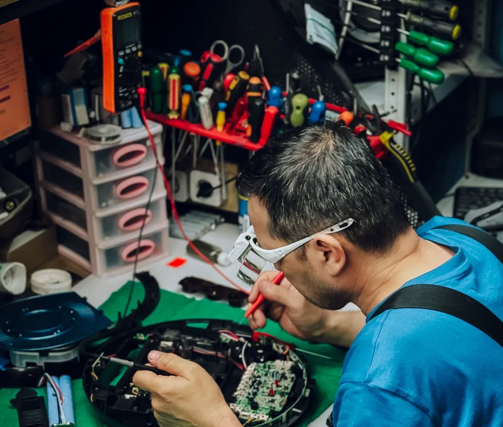 Técnico reparando un equipo electrónico en el taller